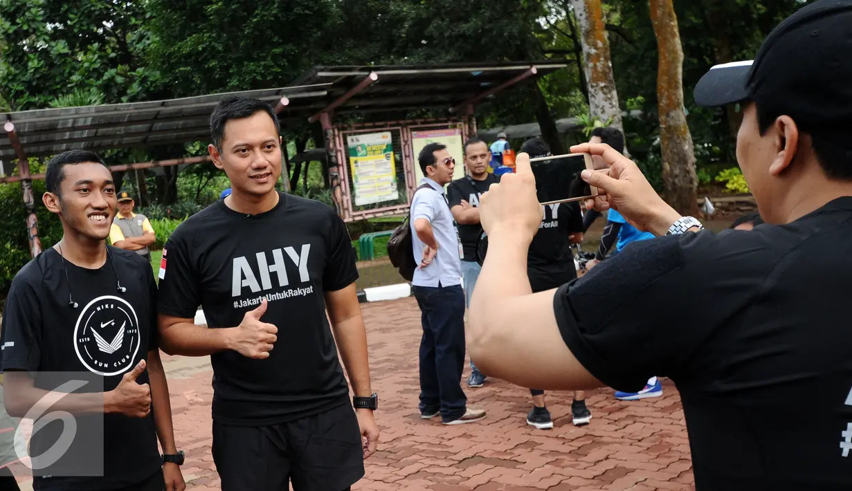 Bakal calon gubernur DKI Jakarta, Agus Harimurti Yudhoyono (tengah) berfoto bersama warga jelang berolahraga di Kebun Binatang Ragunan Jakarta, Minggu (9/10). Selain olahraga, AHY juga melakukan  sosialisasi. (Liputan6.com/Helmi Fithriansyah)