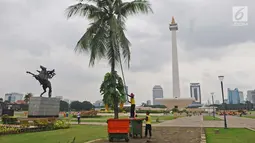 Petugas membersihkan taman di kawasan Monas, Jakarta, Rabu (23/1). Penataan ulang sejumlah taman di kawasan Monas untuk mempercantik kawasan tersebut. (Liputan6.com/Herman Zakharia)