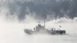 Sebuah kapal saat melintasi sepanjang Sungai Yenisei ditengah kabut dingin di Taiga luar kota Siberia Krasnoyarsk, Rusia, Selasa (17/11/2015). Suhu udara minus hingga 20 derajat Celsius. (REUTERS/Ilya Naymushin)