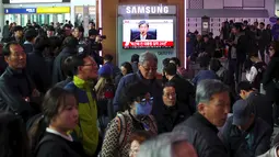 Warga menonton layar TV yang menyiarkan hakim Kim Se-yoon membacakan putusan dalam sidang mantan presiden Korea Selatan Park Geun-hye, Seoul, Korea Selatan, Jumat (6/4). Park Geun-hye divonis 24 tahun penjara. (AFP PHOTO/YONHAP)