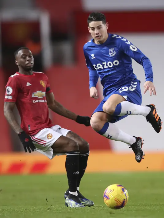 Gelandang Everton, James Rodriguez bersaing dengan bek Manchester United (MU), Aaron Wan-Bissaka pada laga pekan ke-23 Liga Inggris 2020/2021 di Old Trafford, Minggu dinihari WIB (7/2/2021). MU mampu bermain imbang 3-3 saat menjamu Everton. (Alex Pantling/Pool via AP)