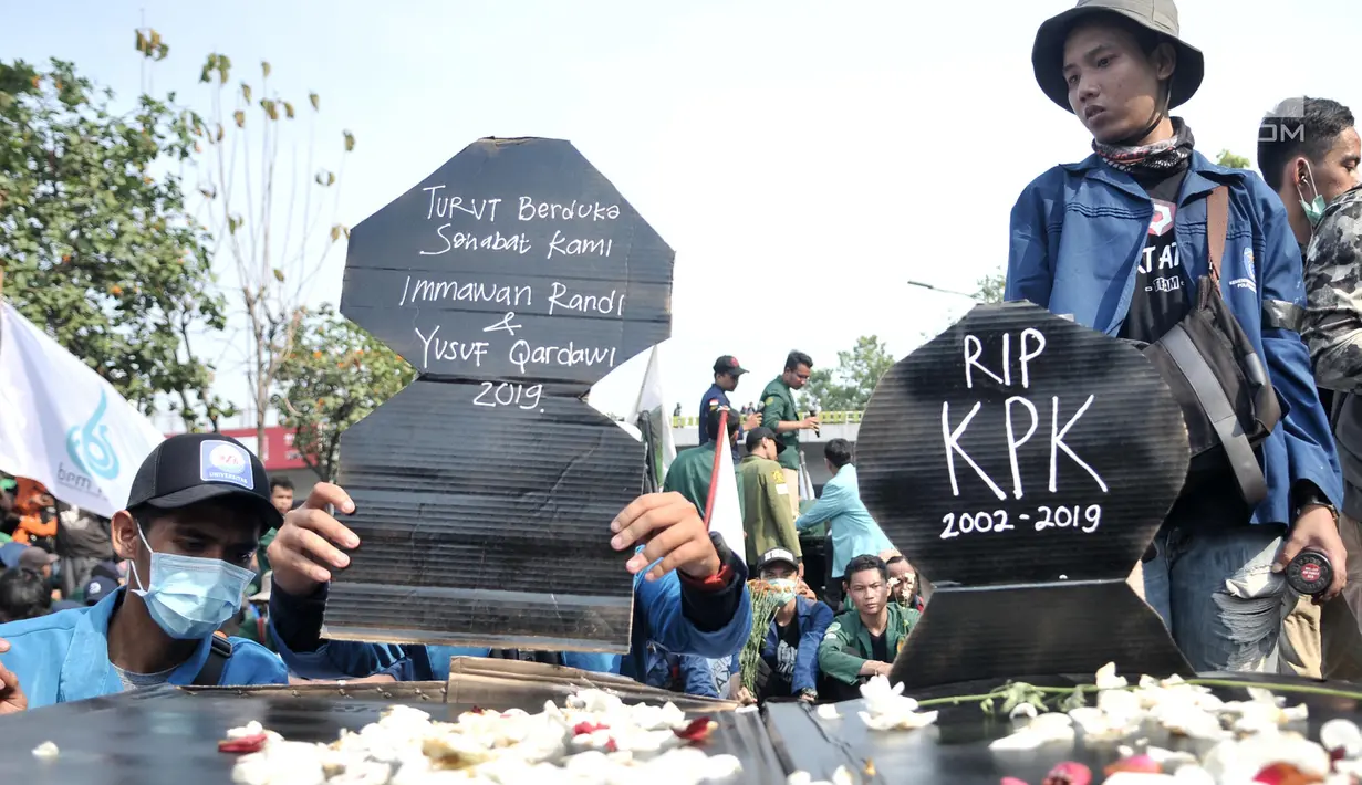 Mahasiswa membawa replika nisan saat menggelar aksi di depan Gedung DPR RI, Jakarta, Selasa (1/10/2019). Replika nisan tersebut merupakan bagian dari aksi teatrikal sebagai bentuk duka cita atas matinya KPK dan tewasnya dua mahasiswa dalam aksi menolak RKUHP. (merdeka.com/Iqbal S Nugroho)