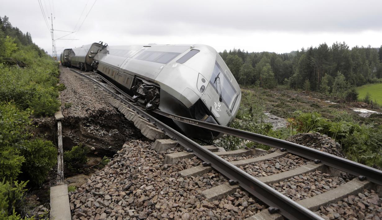 Tergelincirnya kereta tersebut terjadi karena "tanggul rel kereta api telah tergerus oleh hujan deras dan runtuh," kata mereka, seraya menambahkan bahwa tingkat cedera mereka belum jelas. (Mats Andersson/TT News Agency via AP)