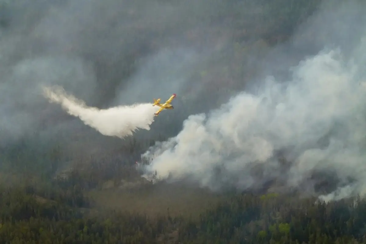 Sebuah pesawat water bomber memerangi kebakaran hutan di wilayah tenggara Manitoba, Kanada, diabadikan dalam potret yang dibagikan pemerintah Manitoba pada Selasa (27/5/2025).