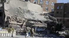 Militan Houthi saat melihat reruntuhan bangunan markas Perdagangan dan Industri yang hancur di Sanaa, Yaman, (5/1). Bangunan ini hancur setelah  mendapat serangan udara dari Arab Saudi. (REUTERS / Khaled Abdullah)