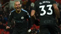 Gelandang Manchester City, David Silva berselebrasi setelah mencetak gol ke gawang Stoke City pada pertandingan pekan ke-30 Premier League di bet365 Stadium, Selasa (13/3). Dua gol kemenangan Manchester City diciptakan oleh David Silva. (PAUL ELLI/AFP)