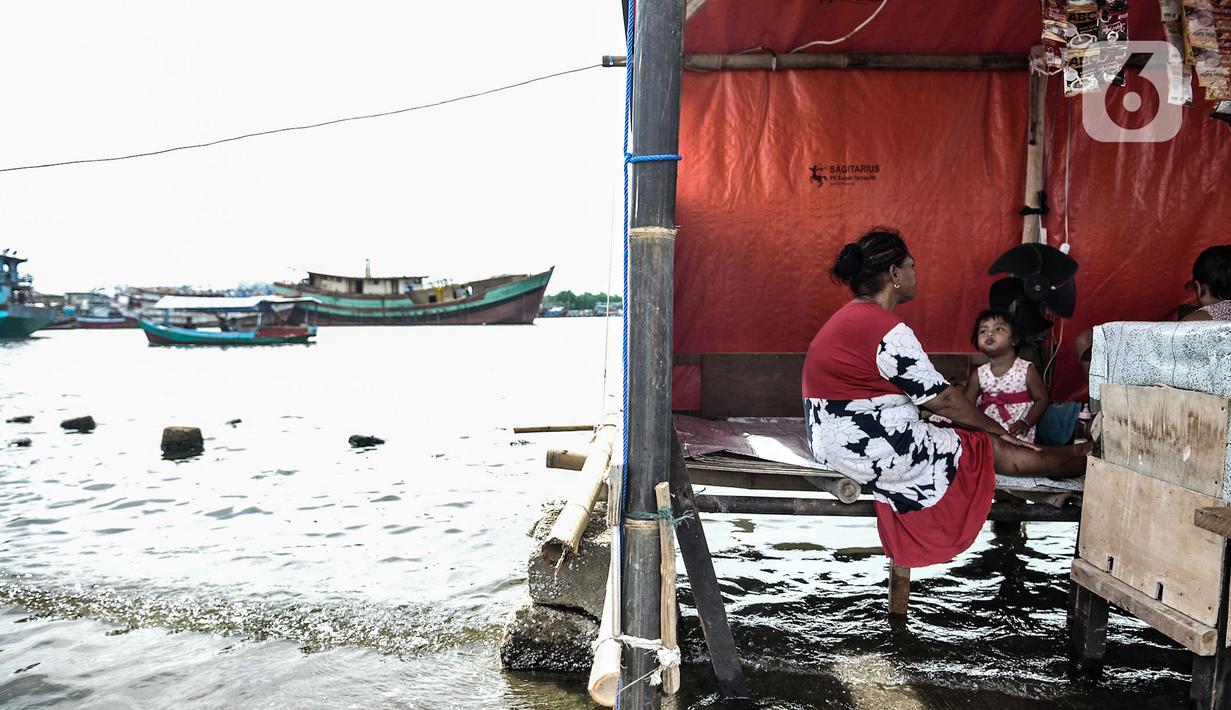 Aktivitas warga saat banjir rob merendam kawasan Pelabuhan Kali Adem, Muara Angke, Jakarta, Kamis (22/10/2020). Banjir akibat air pasang dengan ketinggian mencapai 30 cm tersebut telah merendam kawasan Pelabuhan Kali Adem dan sudah berlangsung selama lima hari. (merdeka.com/Iqbal S. Nugroho)