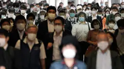 Para penumpang dengan menggunakan masker memenuhi sebuah lorong stasiun selama jam sibuk di Tokyo, Selasa (26/5/2020). Perdana Menteri Jepang Shinzo Abe mencabut keadaan darurat pandemi virus corona di Tokyo dan empat wilayah lainnya pada Senin (25/5). (AP Photo/Eugene Hoshiko)