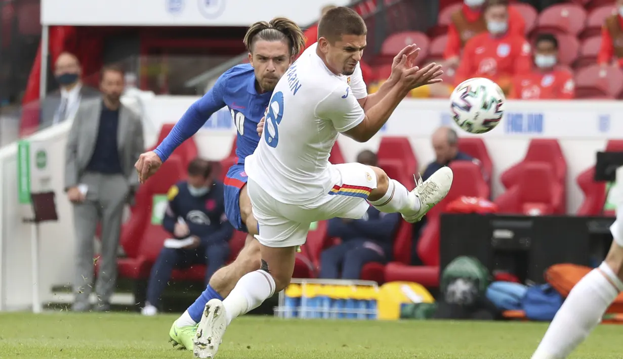 Gelandang Timnas Inggris, Jack Grealish melakukan tendangan di samping gelandang Timnas Rumania, Alexandru Cicaldau pada laga pemanasan jelang Piala Eropa 2020 di Riverside Stadium, Minggu (6/6/2021). Bertanding menghadapi Rumania, Inggris menang tipis 1-0. (AP Photo/Scott Heppell, Pool)