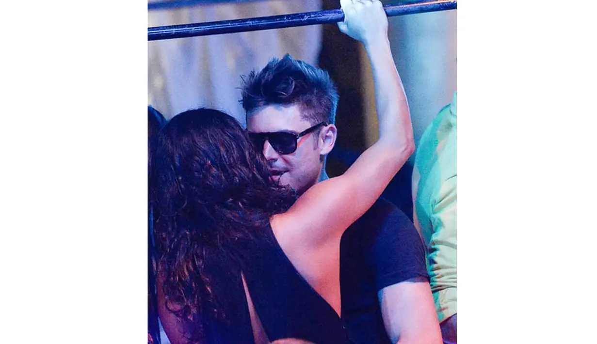 Michelle Rodriguez pun berbalas bisik kepada sang kekasih Zac Efron sambil memegang balok besi di sebuah club, Billionaire Porto Cervo, Sardinia, Italia. (9/7/14) (TMZ.com)