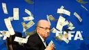 Komedian Inggris, Lee Nelson melempar uang kertas ke arah Sepp Blatter di markas FIFA di Zurich, Swiss. Tingkah Nelson itu dilakukan sebagai bentuk protesnya. (Reuters/Arnd Wiegmann)