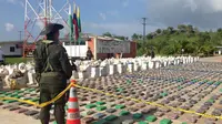 Petugas kepolisian Kolombia menjaga 8 ton paket kokain senilai Rp3,2 triliun yang disita dari sebuah tempat di wilayah Turbo, Antioquia, Minggu (15/5). Selain menyita narkoba, dalam operasi itu polisi juga menangkap 3 orang. (Colombian Police/REUTERS)