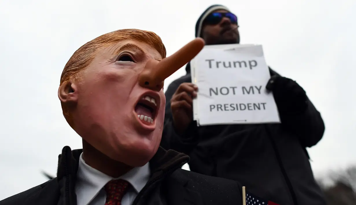 Demonstran menggelar aksi protes jelang pelantikan Donald Trump sebagai Presiden AS di Washington DC, Jumat (20/1). Mereka menolak Trump sebagai Presiden AS. (AFP PHOTO / Jewel SAMAD)