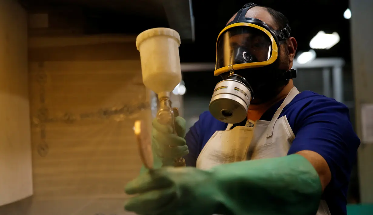 Pekerja melakukan pengecatan pada medali Olimpiade Rio di Casa da Moeda do Brasil (Brazilian Mint), Rio de Janeiro, Brasil, (28/6). Sekitar 5.130 medali akan diselesaikan dalam waktu dua hari. (REUTERS/Sergio Moraes)