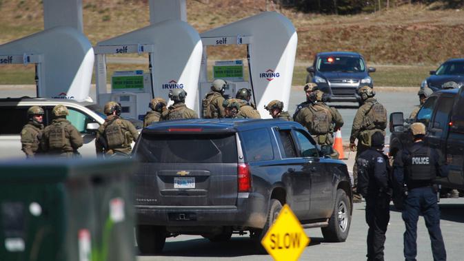 Petugas Polisi Mounted Royal Kanada saat menangkap tersangka di sebuah pom bensin di Enfield, Nova Scotia, Minggu (19/4/2020). Seorang pria bersenjata menewaskan lebih dari 10 orang dalam aksinya, termasuk seorang polisi wanita. (Tim Krochak/The Canadian Press via AP)