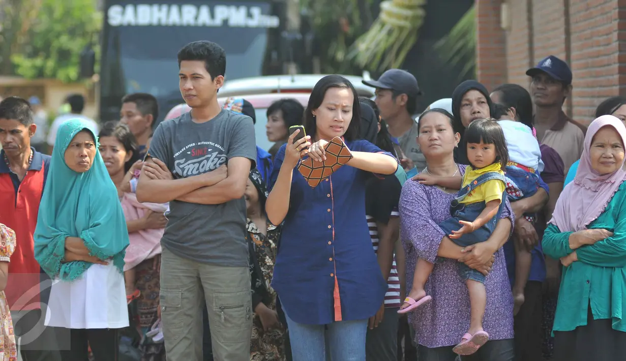 Ratusan warga bejubel di sekitar bedeng tempat Agus Darmawan tinggal, Jakarta, Minggu (11/10/2015). Warga penasaran ingin melihat rekonstruksi pembunuhan PNF.(Liputan6.com/Gempur M Surya)