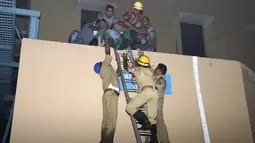 Salah satu korban berhasil dievakuasi oleh petugas pemadam saat kebakaran melanda rumah sakit SUM Bhubaneshwar di Odisha, India Timur, Senin (17/10). Sebagian besar korban dilaporkan meninggal karena kehabisan napas akibat menghirup asap. (AFP)