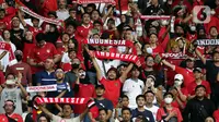 Pendukung timnas Indonesia membentang syal saat menyaksikan laga kualifikasi Grup A Piala AFF 2022 antara Indonesia melawan Kamboja di di Stadion Utama Gelora Bung Karno, Jakarta, Jumat (23/12/2022). Indonesia unggul 2-1 atas Kamboja lewat gol yang dicetak Egy Maulana Vikry dan Witan Sulaeman. (Liputan6.com/Helmi Fithriansyah)