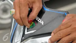 Sebuah stiker berlambang Polisi Militer dicopot saat Operasi Gaktib Garnisun Tetap 1 di kawasan Pesing, Jakarta,  Kamis, (11/2/2016). Razia ini yang dilakukan untuk menertibkan aksesoris berlambangkan TNI dan Polri. (Liputan6.com/Faisal R Syam)