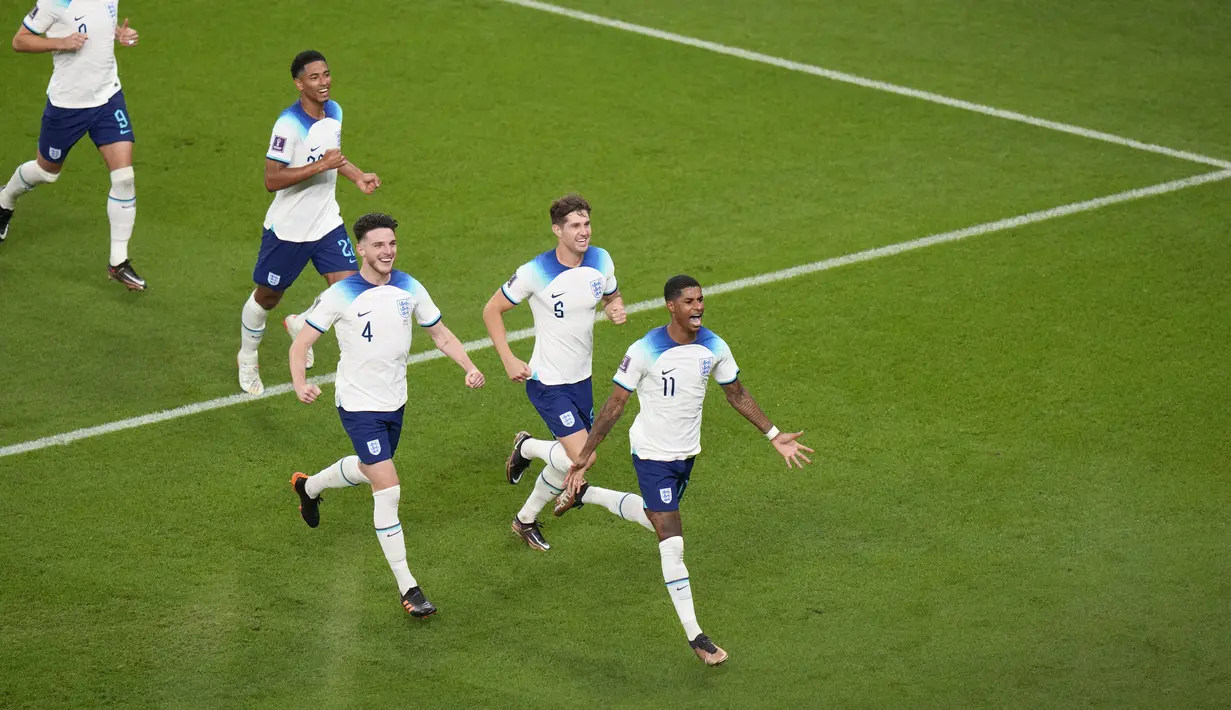 <p>Pemain Inggris, Marcus Rashford (kanan) merayakan gol kedua timnya ke gawang Wales saat matchday ketiga Piala Dunia 2022 di Ahmad Bin Ali Stadium, Rabu (30/11/2022). (AP/Alessandra Tarantino)</p>