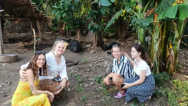 Wisatawan asing dari Jerman sedang melihat babi hitam saat berlibur di Desa Wisata Pemuteran, Bali