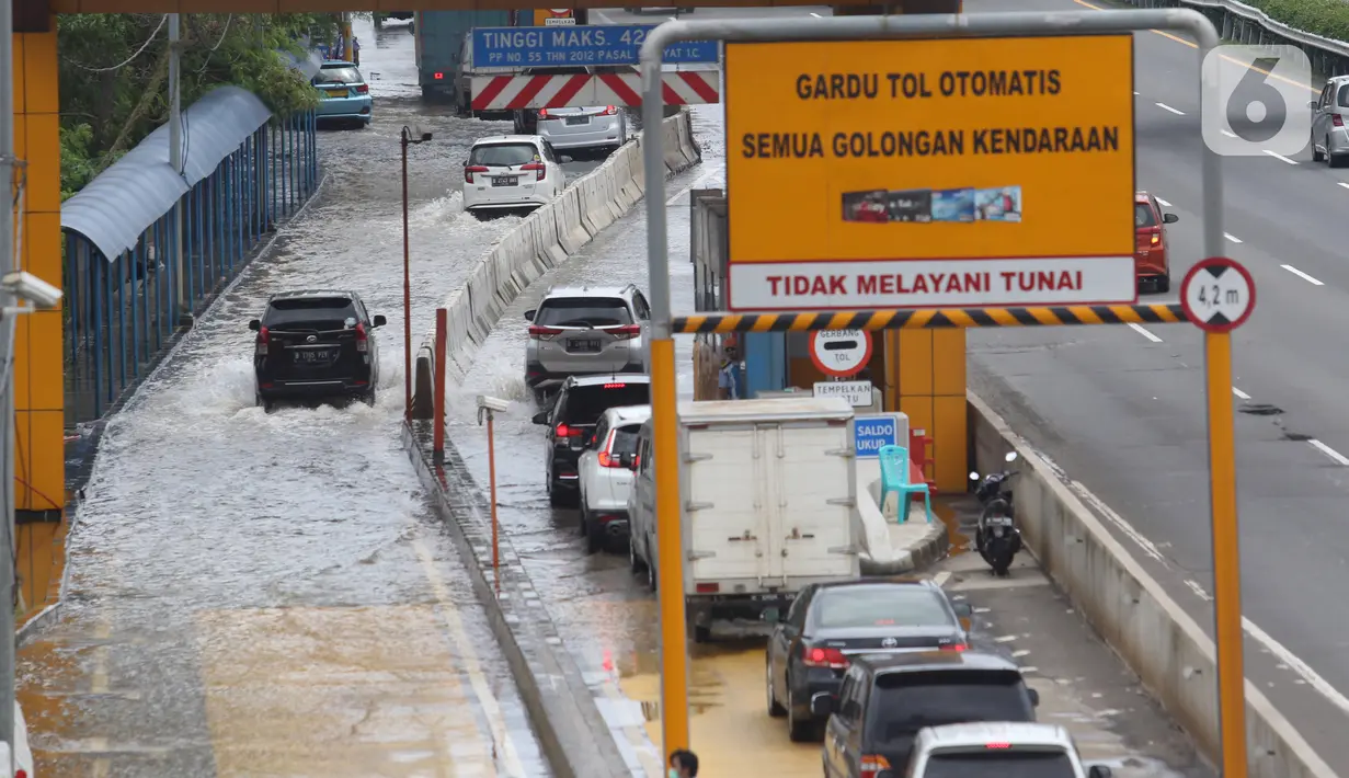 Sejumlah kendaraan melintasi Gerbang Tol Karang Tengah Barat 2 yang masih terendam banjir, Tangerang, Banten, Kamis (2/1/2020). Banjir setinggi betis orang dewasa masih menggenangi Gerbang Tol Karang Tengah Barat 2. (Liputan6.com/Angga Yuniar)