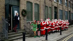 Sejumlah pria mengenakan kostum Santa Claus berbaris saat sesi pemotretan di Ragged School Museum di London (16/11). Sekolah tersebut mengajarkan pria dari usia muda hingga tua mengenai sejarah dan kebudayaan Santa Claus. (AP Photo/Matt Dunham)