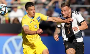 Pemain Timnas Jerman, David Raum (kiri), berebut bola dengan pemain Timnas Ukraina, OleksandrTymchyk, dalam laga persahabatan internasional FIFA Matchday 2023 yang digelar di Weserstadion, Bremen, Senin (12/6/2023) malam WIB. (AP Photo/Martin Meissner)