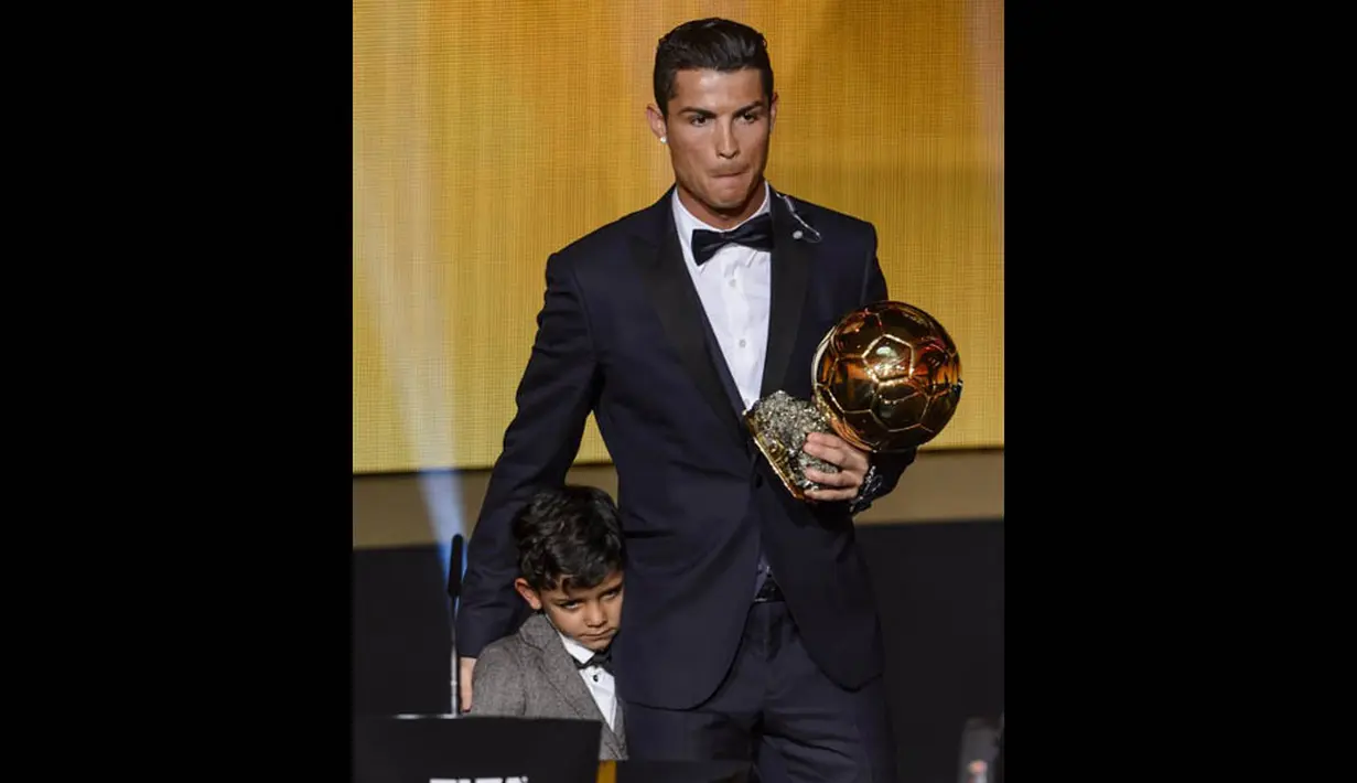 Cristiano Ronaldo mengajak putranya, Cristianinho untuk naik ke atas panggung saat meraih penghargaan Ballon d'Or 2014 di Swiss, Senin (12/1/2015). (AFP PHOTO/Fabrice COFFRINI)