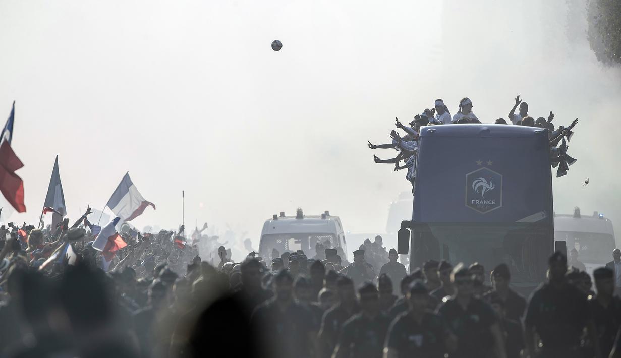 Skuat Prancis menyapa fans saat parade juara di di Champs-Elysee avenue, Paris, (16/7/2018). Prancis berpesta merayakan keberhasilan Les Bleus meraih trofi Piala Dunia 2018. (AP/Jean-Francois Badias)