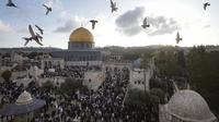 Warga Palestina menghadiri perayaan hari raya Idul Fitri di Masjid Dome of the Rock di kompleks Masjid Al Aqsa di Kota Tua Yerusalem, Jumat, 21 April 2023. Hari raya tersebut menandai berakhirnya bulan suci Ramadhan, saat umat Islam yang taat berpuasa dari matahari terbit sampai terbenam. (AP Photo/Mahmoud Illean)