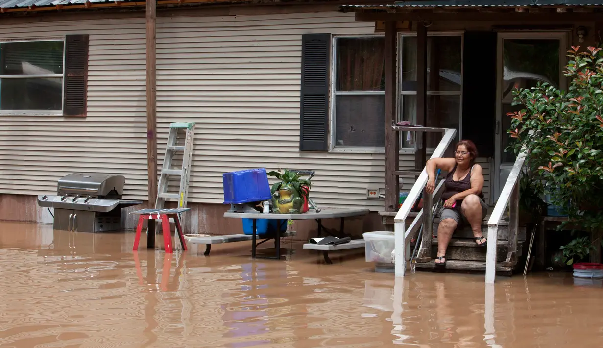 Honorina Paniagua duduk di tangga rumahnya saat banjir merendam kawasan Richmond, Texas, Selasa (31/5). Bencana banjir terjadi lantaran Sungai Brazos meluap akibat hujan deras yang mengguyur wilayah tersebut. (REUTERS/Daniel Kramer)