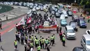 Petugas kepolisian saat menghadang para pengendara motor yang mencoba untuk masuk ke jalan MH Thamrin,  Jakarta, Minggu (22/12/2014). (Liputan6.com/Johan Tallo)