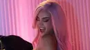 Rambut panjangnya terurai soft pink dengan model terurai wavy. Wajahnya dipulas blush on pink di pipinya. Dengan lipstik warna pink gelap. [@kyliejenner]