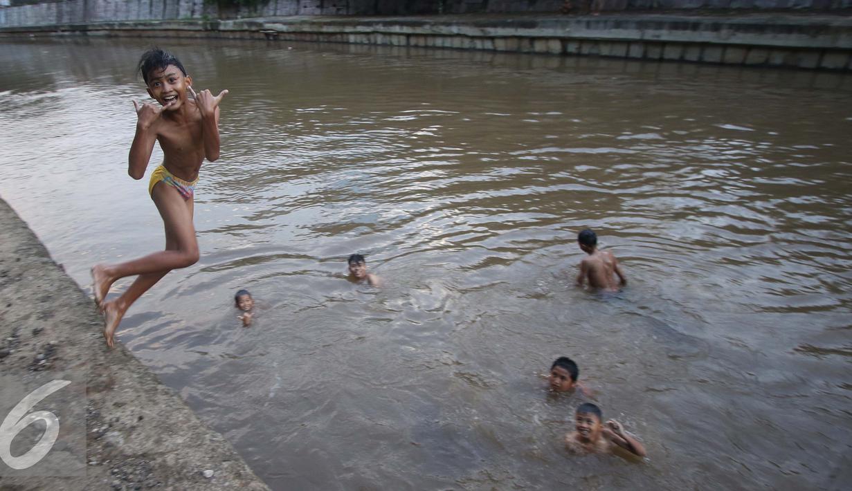 Sejumlah anak berumur belasan tahun riang gembira mandi di sungai Ciliwung, Jakarta, Rabu (16/11). Air di Sungai Ciliwung yang mulai bersih menjadi daya tarik anak-anak ini untuk mandi di sana. (Liputan6.com/Gempur M Surya)