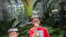 Dua anak dari Toronto, Kanada, menutup hidung mereka saat melihat bunga bangkai raksasa Titan Arum di Botanic Garden, Washington, Amerika Serikat, Senin (2/8). Bunga bangkai raksasa dari Sumatera ini tak lama lagi akan mekar sempurna. (Chris KLEPONIS/AFP)