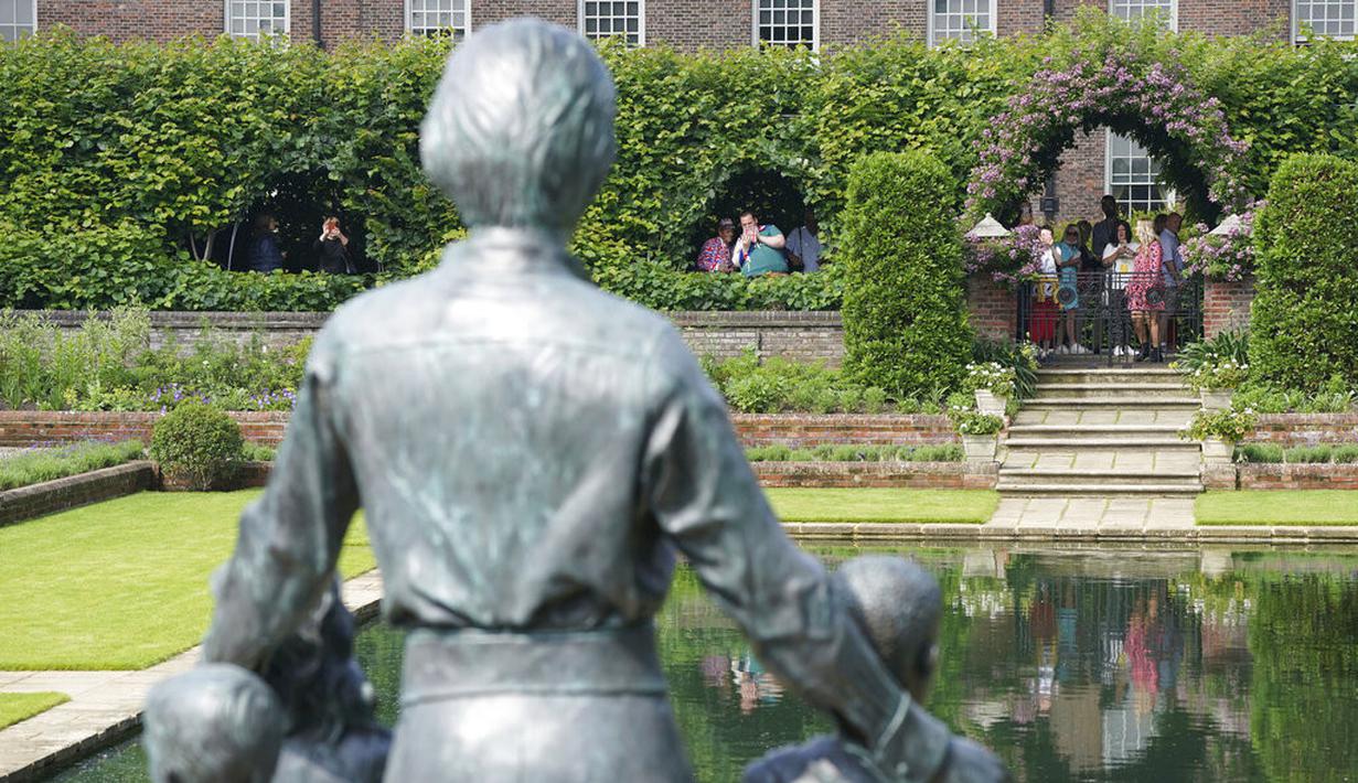 Anggota masyarakat melihat patung Dianam di Taman Sunken di Istana Kensington, London, Jumat (2/7/2021). Peresmian patung ini menandai ulang tahun ke-60 tahun Putri Diana.  (Jonathan Brady/Pool Photo via AP)