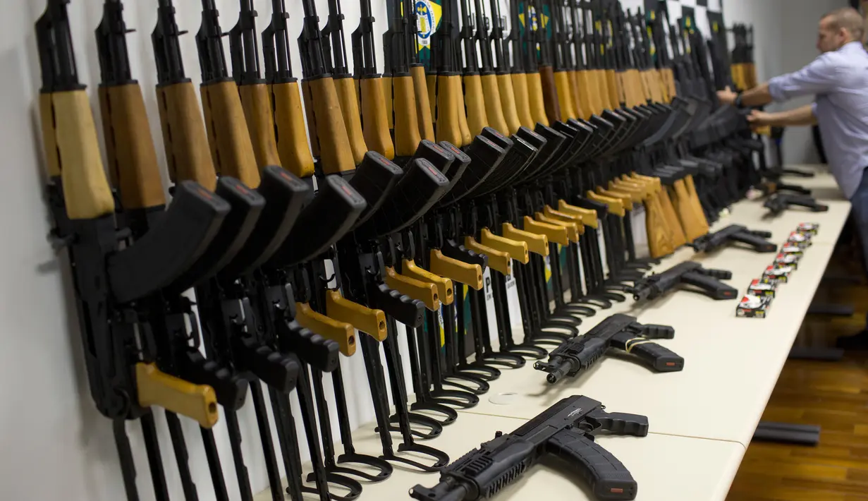 Polisi Brasil menunjukkan 60 senapan serbu yang disita saat konferensi pers di Rio de Janeiro, 1 Juni 2017.  Penyitaan senjata militer ini diklaim sebagai yang terbesar di Brasil selama satu dekade itu. (AP Photo/Silvia Izquierdo)