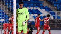 Kiper Real Madrid Thibaut Courtois tertunduk lesu usai Ivan Rakitic cetak gol (AFP)