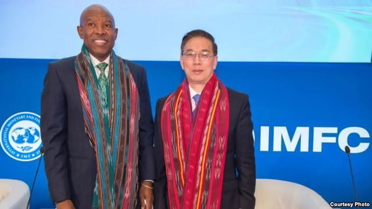 Dua pejabat tinggi IMF, Lesetja Kgangyago (kiri) dan Jianhai Lin memamerkan kain ulos kepada wartawan. (Foto courtesy: IMF-World Bank)