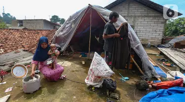 Warga beraktivitas pada tenda darurat yang dibangun di atas rumah pasca banjir melanda kawasan Pejaten Timur, Jakarta Selatan, Senin (8/1/2024). (merdeka.com/Arie Basuki)