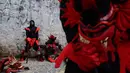 Seorang peserta mengenakan kostum setan beristirahat di sela-sela festival Congos and Devils di luar benteng San Jeronimo di Portobelo, Panama (18/3). (AP Photo/Arnulfo Franco)