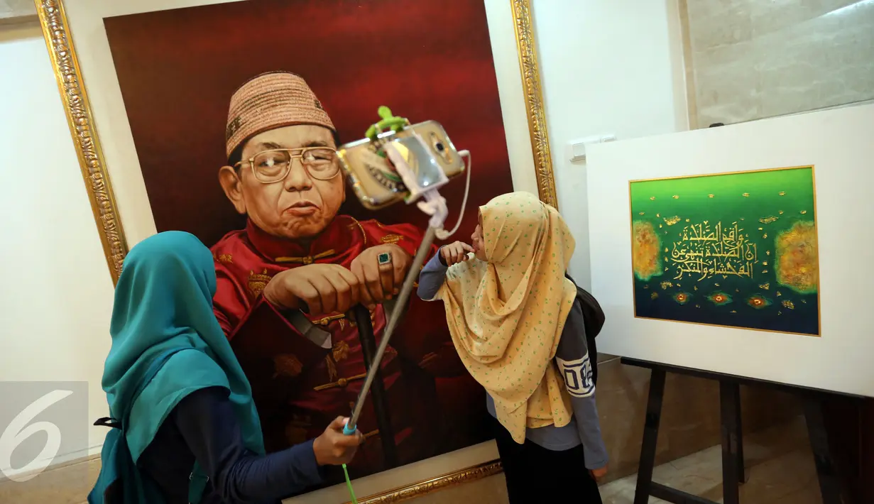 Pengunjung berfoto di dekat lukisan Presiden RI ke-4 Abdurrahman Wahid (Gusdur) saat pameran di Gedung PBNU, Jakarta, Senin (30/1). Pameran tersebut digelar dalam rangka Harlah NU ke-91. (Liputan6.com/Johan Tallo)