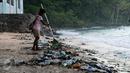 Warga berusaha membersihkan sampah di pantai Pasir Putih, Manokwari, Papua Barat, Senin (15/8/2016). Tampak, sisa botol berserakan, kondisi ini bisa mengurangi daya tarik wisatawan menikmati keindahan alam Papua Barat. (Liputan6.com/Helmi Fithriansyah)