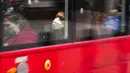 Seorang wanita mengenakan masker saat dia duduk di bus, di London, Kamis (16/12/2021). Kepala petugas medis Inggris memperingatkan Situasi kemungkinan akan bertambah buruk karena varian omicron mendorong gelombang penyakit baru selama liburan Natal. (AP Photo/Alberto Pezzali)