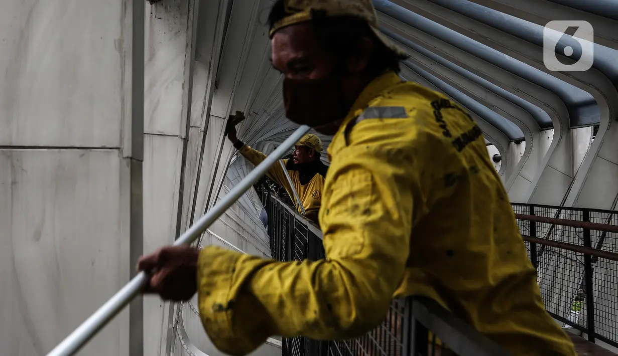 Aktivitas perawatan Jembatan Penyeberangan Orang (JPO) oleh pasukan kuning dari Dinas Bina Marga DKI Jakarta di Kawasan Sudirman, Senin (29/3/2021). Kegiatan tersebut dilakukan agar bersih terhidar dari debu serta para pemakai jembatan itu merasa aman dan nyaman. (Liputan6.com/Johan Tallo)
