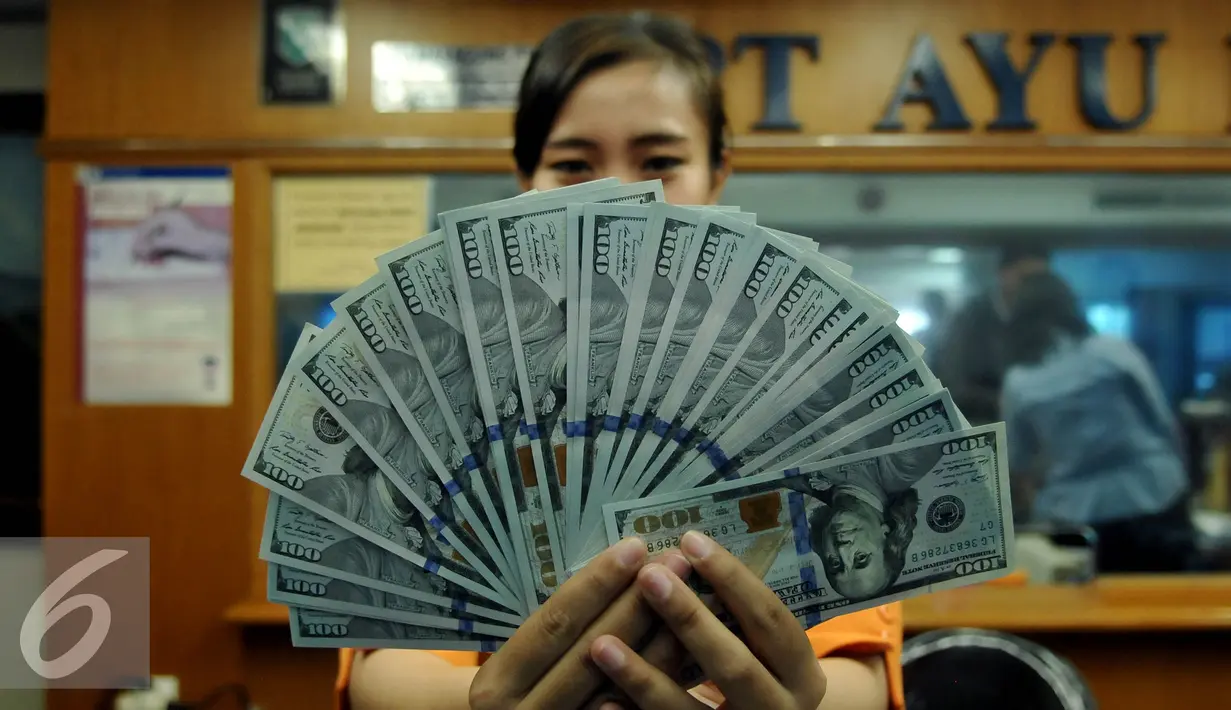 Petugas memperlihatkan uang pecahan US$100 di penukaran uang, Jakarta, Rabu (12/8/2015). Reshuffle kabinet pemerintahan Jokowi-JK, nilai Rupiah terahadap Dollar AS hingga siang ini menembus Rp 13.849. (Liputan6.com/Johan Tallo)