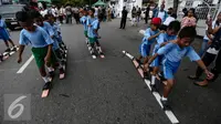 Sejumlah murid sekolah dasar mengikuti balap bakiak dalam festival  permainan tradisional rakyat Maluku didepan Balai Kota Ambon, Maluku, Senin (7/2). Festival tersebut diselenggarakan untuk memperingati Hari Pers Nasional. (Liputan6.com/Faizal Fanani)
