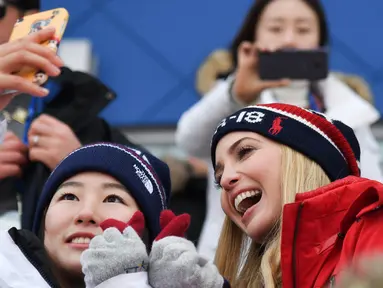 Putri Presiden AS Donald Trump yang juga penasihat senior Gedung Putih, Ivanka Trump (kanan) berswafoto dengan atlet Korea Selatan saat menonton snowboard pria pada Olimpiade Musim Dingin Pyeongchang 2018, Korea Selatan, Sabtu (24/2). (Ed JONES/AFP)