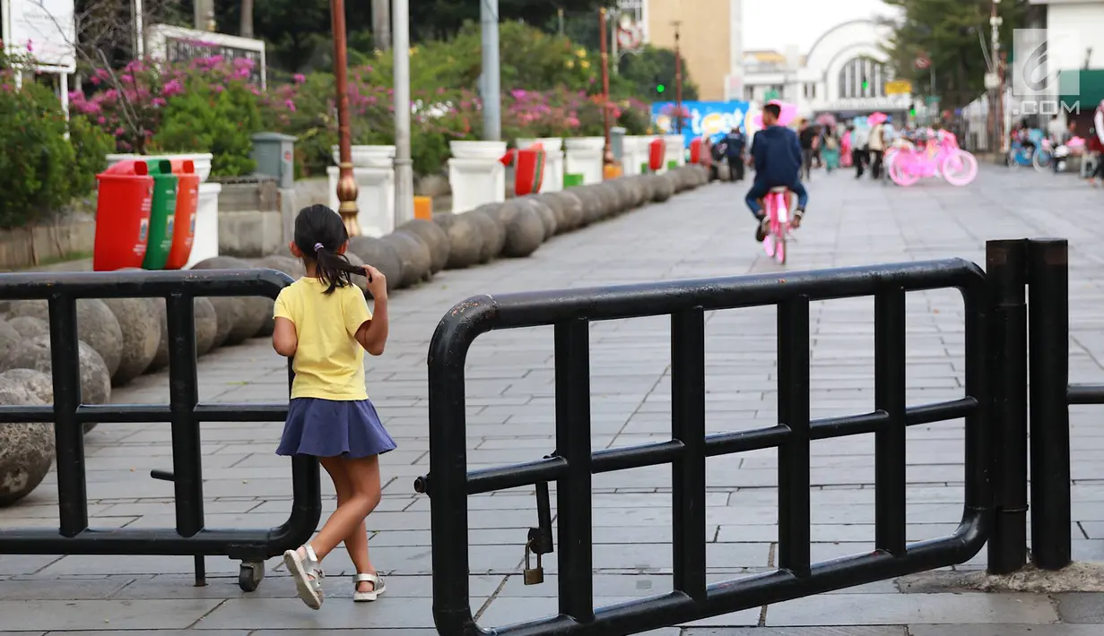 Pejalan kaki melintasi jalur masuk dan keluar Taman Fatahilah, Kota Tua, Jakarta, Selasa (23/4). Unit Pengelola Kawasan (UPK) Kota Tua melakukan uji coba simulasi pengaturan alur pintu masuk dan pintu keluar ke Taman Fatahillah bagi pejalan kaki selama dua minggu. (Liputan6.com/Immanuel Antonius)
